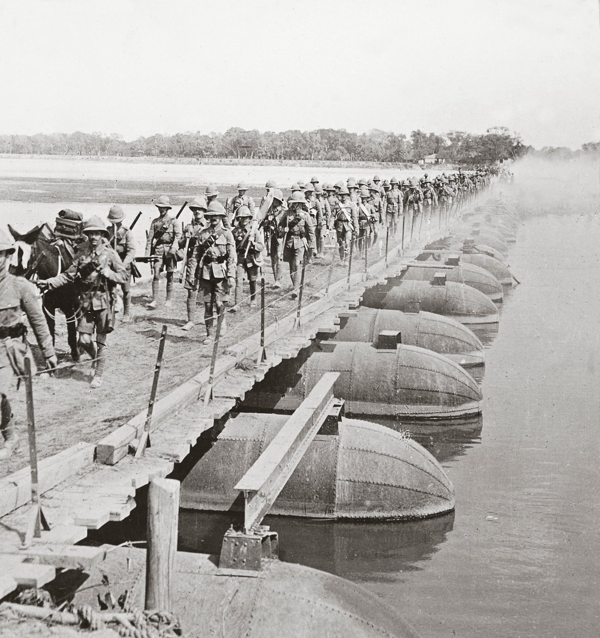 Maschinengewehrabteilung und Infanterie überqueren einen überfluteten Fluss auf einer Pontonbrücke von English Photographer