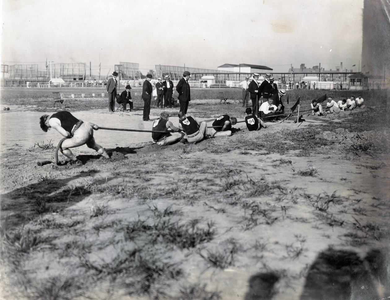 Horizontales Foto von zwei Teams, die im Tauziehen gegeneinander antreten. Hinter dem Seil stehen Richter. Die Schatten der Zuschauer sind im Foto zu sehen von Jessie Tarbox Beals