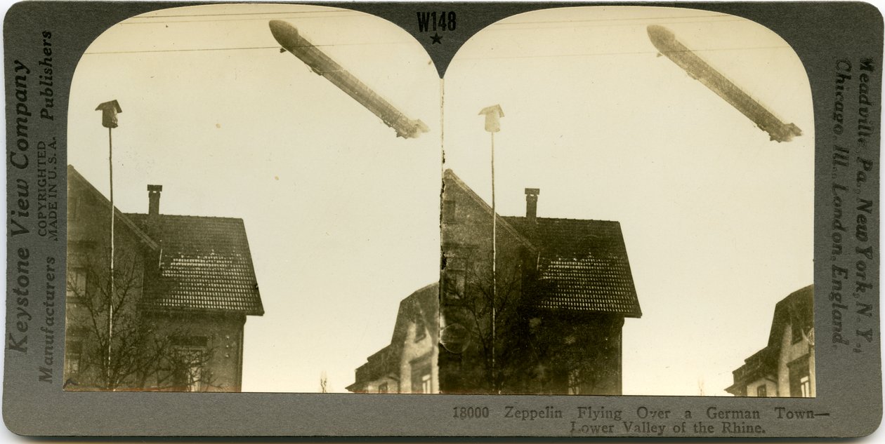 Horizontale, sepiafarbene Stereokarte, die ein Zeppelin zeigt, der über die Dächer einer Stadt fliegt. Keystone Stereograph Nummer 18000. Der Titel lautet von Keystone View Company