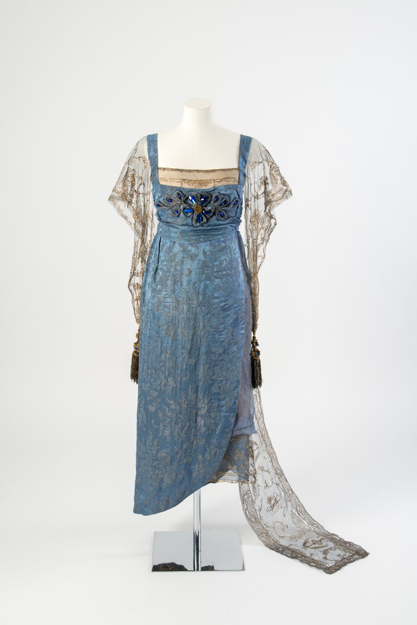 Blau gemustertes Seidenabendkleid mit goldenen Netzärmeln und Zug, bestickt mit Goldmetallstreifen und verziert mit blauen Edelsteinen und Quasten, 1911 von Lucy Christiana, Lady Duff Gordon