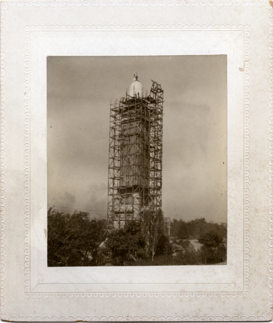 Bau des Compton Heights Wasserturms über bestehendem Steigrohr, mit Gerüst um den Turm und Arbeiter auf Dachebene von Unknown