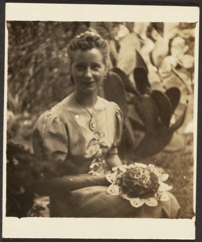 [Frau mit Blumenstrauß vor Kaktus sitzend] von Louis Fleckenstein