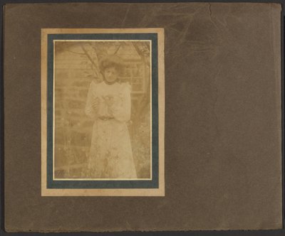 [Frau hält Blume im Garten] von Louis Fleckenstein